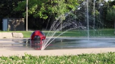 Güneşli bir yaz gününde yerel halk parkında su sıçratma yeri. İnsansız çeşme.