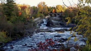 Sonbaharda Kanada 'nın Ottawa şehrindeki Rideau Nehri' ndeki Galler Şelaleleri Prensi Hogs Back Falls ve Bridge. Nehirle parkın renkli doğası