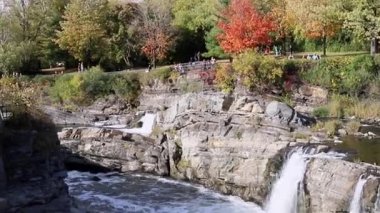 Ottawa, Kanada - 11 Ekim 2021: The Hogs Back Falls and Bridge, Prince of Wales Falls şelaleleri Ottawa 'nın Rideau Nehri üzerinde sonbaharda. Nehirle parkın renkli doğası