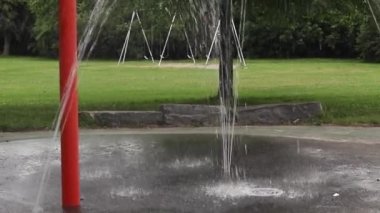 Yaz günü parktaki çocuk parkında sıçrama tahtası ve salıncaklar. Akan suyla çeşme