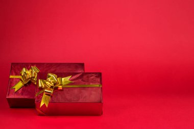 Kırmızı arka planda hediyeleri olan bir Noel arkaplanı.