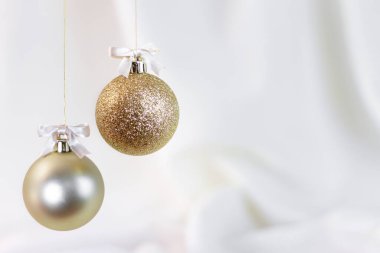 Altın Noel küreleri ile beyaz kumaş arka plan.