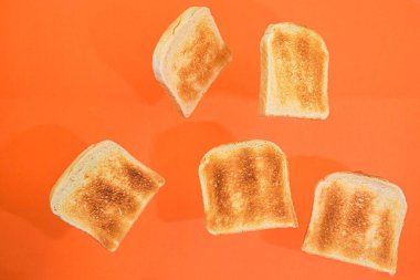Turuncu pastel arka planda kızarmış ekmek parçaları. Turuncu arka planda taze kızarmış ekmek parçaları.