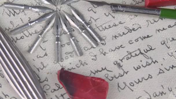 Set de plume en métal, stylo vintage, cire d'étanchéité, tampon en bois et couteau en papier sur écriture vintage. Pose plate. Images tournantes. — Video
