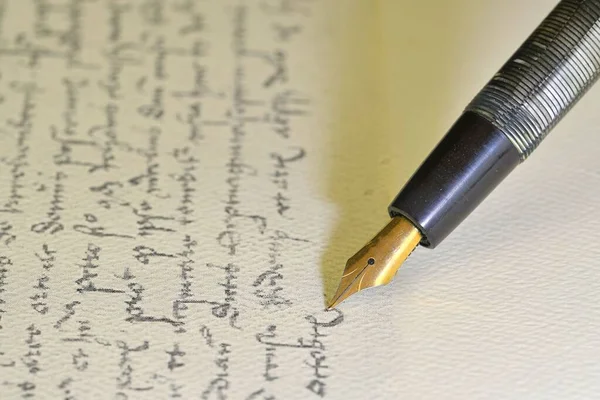 Фонтанная ручка на бумаге с чернильным текстом на винтажном почерке. Крупный план. Фонтанная ручка на старинном рукописном письме — стоковое фото