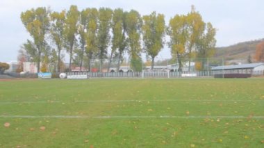Sonbaharda atletik stadyum. Sonbaharda terk edilmiş atletizm stadyumu. Futbol sahasında panoramik manzara. Bitmiş atletizm ve futbol sezonu kavramı