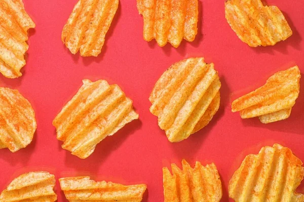 Ribbed potatoes snack with pepper on red background. Ridged potato chips on red background. Set of potato chips. Flat lay. Close-up — Stock Photo, Image