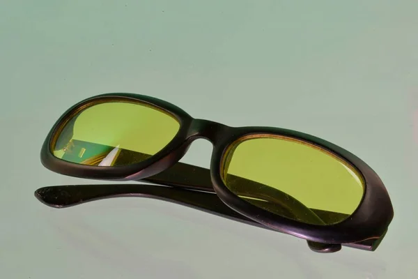 Reflet des lunettes de soleil. Lunettes de soleil vertes, gros plan. Lunettes de soleil. Lunettes de soleil à l'ancienne. Lunettes avec verres transparents. Lunettes de soleil vintage sur fond réfléchi. Gros plan sur les lunettes de soleil usées — Photo