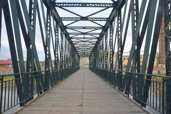 Paso elevado de metal viejo, puente sobre el río. Puente de metal remache en la ciudad — Foto de Stock