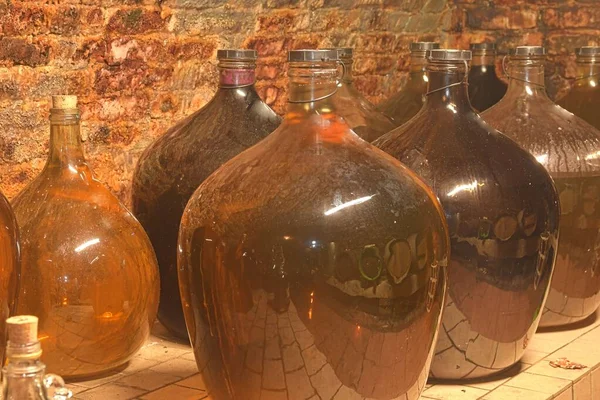 Винтажные полуджоны в традиционном винном погребе. Бутылки вина Demijohn — стоковое фото