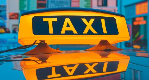 Lit cartel de taxi en el techo del coche de taxi en la ciudad — Foto de Stock