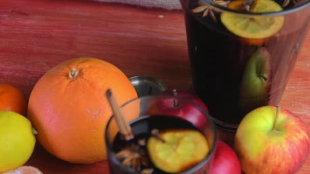 Christmas hot mulled wine with cinnamon, cloves and anise star on a wooden background. Hot mulled wine for winter and Christmas on a wooden rustic table. Red hot wine in a jug — Stockvideo