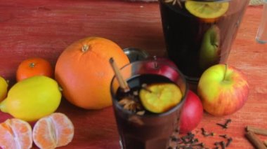 Noel ya da yeni yıl sıcak kış içeceği, baharatlı içki kokteyli, sangria ya da çay, limon, rom, tarçın ve anason ile sıcak şarap. Kırsal tarzda. Noel, kırmızı şarabı ahşap bir masada bir bardakta ısıttı.