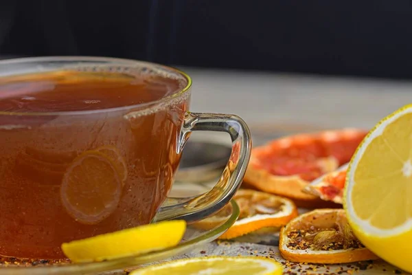 一杯热茶 热气加红葡萄酒 玻璃杯红茶 肉桂棒 茴香星 柠檬和干果白色木制桌子背景 宏观形象 — 图库照片