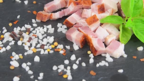 Kostky slaniny, bazalky a koření na otočném břidlicovém podnosu. Nakrájené slaninové kostky, bazalka a koření na rotační břidlicový talíř. Makro — Stock video