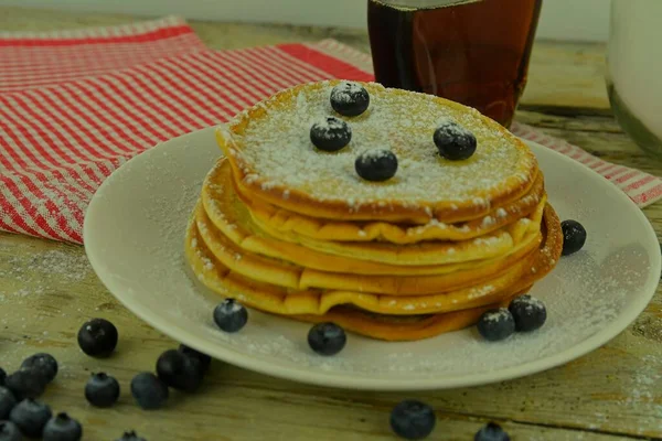 Pancake lezat dengan blueberry segar dan sirup di meja kayu pedesaan. Sirup Maple dan blueberry di tumpukan pancake. Meja putih berkarat. Close-up — Stok Foto