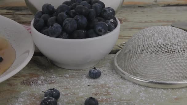 Pila de panqueques de suero de leche americano con bayas y jarabe de arce. Sabrosa comida dulce para el desayuno. Panqueques sobre fondo rústico blanco — Vídeo de stock