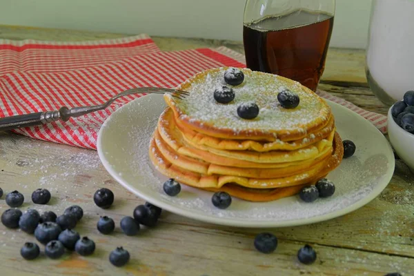 Heerlijke pannenkoeken met verse bosbessen en siroop op een rustieke houten tafel. Ahornsiroop en bosbessen op een stapel pannenkoeken. Rustieke witte tafel. Close-up — Stockfoto