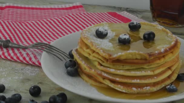 Xarope de bordo em pilha de panquecas de aveia. Panquecas vegetarianas e veganas saudáveis com bagas e xarope de bordo. Comida saborosa e doce. Panquecas sobre fundo branco rústico — Vídeo de Stock