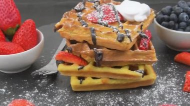 Kahvaltıda Belçika waffle 'ı ya da üzerine taze yaban mersini, çilek, erimiş çikolata ve krem şantili kahvaltı. Dönen waffle yığını.