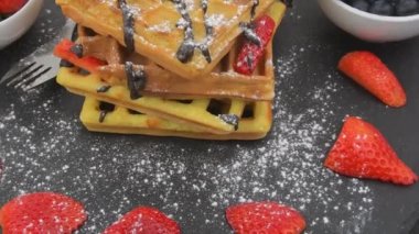 Kahvaltıda Belçika waffle 'ı ya da üzerine taze yaban mersini, çilek, erimiş çikolata ve krem şantili kahvaltı. Dönen waffle yığını