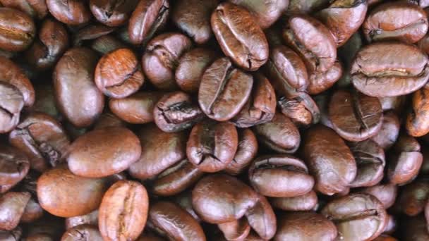 Ψητά φασόλια καφέ με θέα. Κοντινό πλάνο των καφέ καβουρδισμένων κόκκων καφέ εκ περιτροπής. Μακρο. Άλμα βιολογικών σκουρόχρωμων σπόρων καφέ — Αρχείο Βίντεο