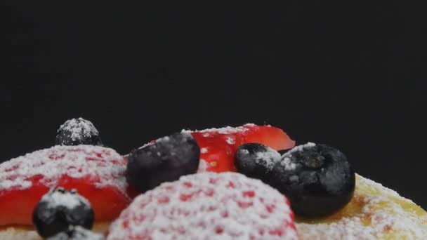 Colazione estiva salutare, pancake americani classici fatti in casa con bacche fresche e zucchero a velo. Fondo nero. Copia spazio — Video Stock