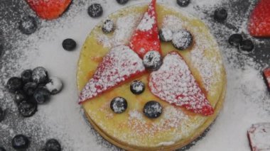 Siyah arka planda kahvaltıda böğürtlenli krep ve akçaağaç pekmezi. Üst Manzara. Dönen yiyecekler