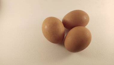 Krem arkaplana 3 tavuk yumurtası yerleştir.