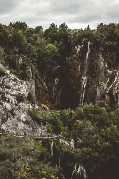 瀑布落在被绿树环绕的岩石上 — 图库照片