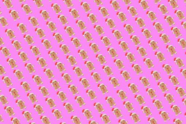 Yeni yıl konsepti. Parlak açık pembe arka planda Noel zencefilli çörekçisi ile yapılan modaya uygun bir model. Asgari yaratıcı konsept. Yaratıcı Noel süsü. Pastel renkler