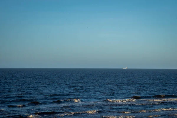 蓝水的海景 白沫的浪花 从地平线上的距离可以看到运输船 — 图库照片