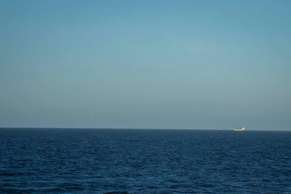 蓝水的海景 白沫的浪花 从地平线上的距离可以看到运输船 — 图库照片