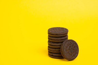 Sarı arka planda izole edilmiş kremalı çikolatalı kurabiyeler..