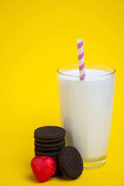 バレンタインデーにはクッキーとハート型のキャンディー 黄色の背景にはミルクのグラス — ストック写真