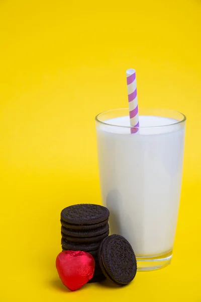 バレンタインデーにはクッキーとハート型のキャンディー 黄色の背景にはミルクのグラス — ストック写真