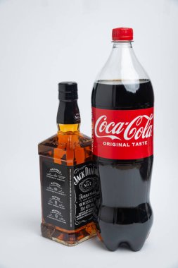Riga, Letonya 12 Şubat 2022: Coca-Cola plastik şişesi ve Jack Daniel viskisinin beyaz arka planda izole edilmiş fotoğrafı