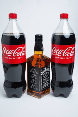 Riga, Letonya 12 Şubat 2022: Coca-Cola plastik şişesi ve Jack Daniel viskisinin beyaz arka planda izole edilmiş fotoğrafı