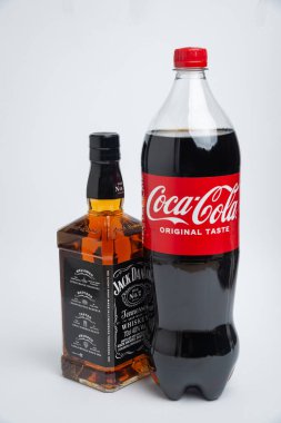 Riga, Letonya 12 Şubat 2022: Coca-Cola plastik şişesi ve Jack Daniel viskisinin beyaz arka planda izole edilmiş fotoğrafı