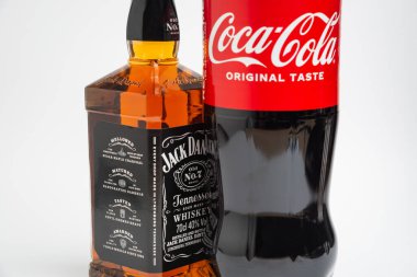 Riga, Letonya 12 Şubat 2022: Coca-Cola plastik şişesi ve Jack Daniel viskisinin beyaz arka planda izole edilmiş fotoğrafı
