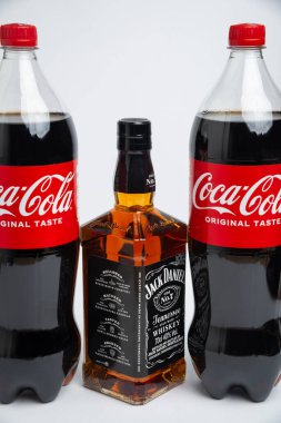 Riga, Letonya 12 Şubat 2022: Coca-Cola plastik şişesi ve Jack Daniel viskisinin beyaz arka planda izole edilmiş fotoğrafı