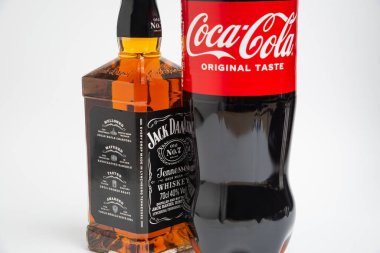 Riga, Letonya 12 Şubat 2022: Coca-Cola plastik şişesi ve Jack Daniel viskisinin beyaz arka planda izole edilmiş fotoğrafı