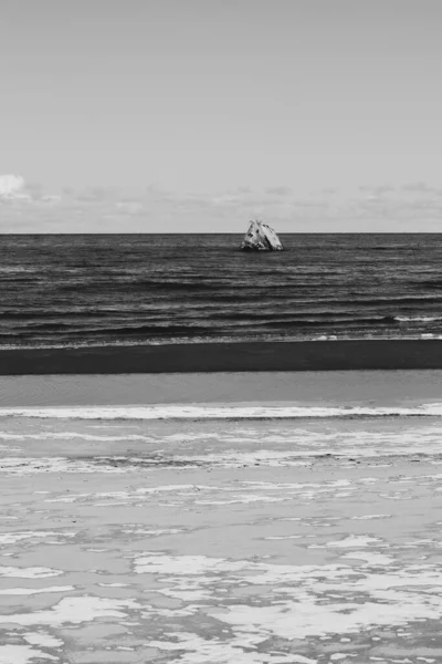 早春的海滨风景带着残留的积雪在海沙中 在岸上可以看到被冲垮的沉船 — 图库照片