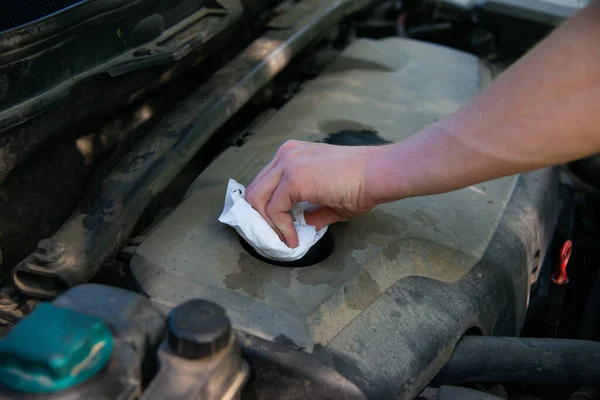 Man\'s hand unscrews the cap of the oil filler neck of the engine. Mechanic gloves change engine oil, service engine.