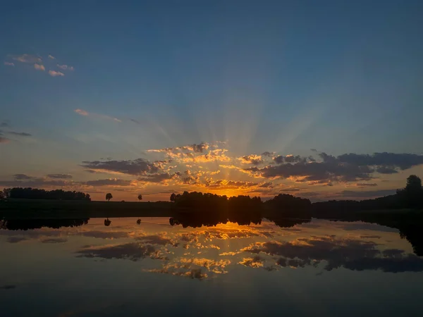 美しい風景 湖のそばに美しい黄金のオレンジの夕日 太陽の光は雲を通して輝きます 湖の水は美しいオレンジの夏の夜の夕日を反映しています 水の中の完璧な反射は — ストック写真