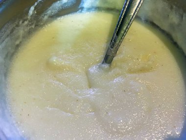 Bir kase leziz irmik pudingi ve yakın plan gri kaşık..