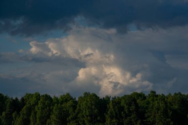 Karanlık, kasvetli gökyüzü. Mavi gökyüzüne karşı gündüz ışığı olan gri bulutlar. Dramatik kara bulutlar gökyüzü. Doğal manzara manzarası