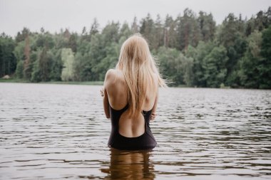 Genç ve güzel bir kadın suyun içinde duruyor..