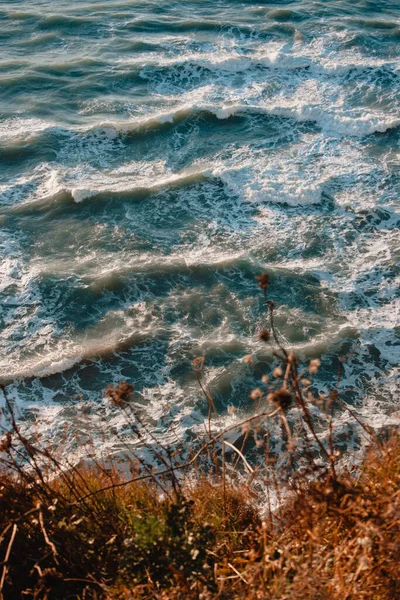 在沙岩悬崖壁上 蓝色的海水波涛汹涌 白色的泡沫冲刷着海岸 — 图库照片