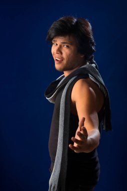 Portrait of a young man posing and showing his muscular body. The concept of a healthy lifestyle on blue background.